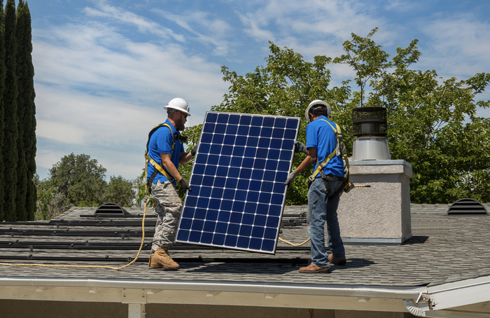 zonne-installateurs op dak van huis met een zonnepaneel