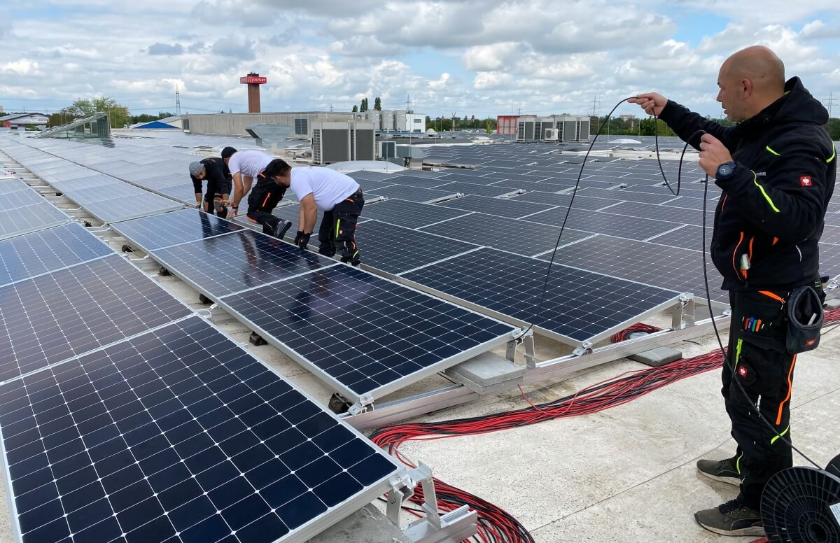 Zusammenarbeit von SolarActiv und Betty Barclay auf dem Dach, um die Solaranlage fachgerecht in Betrieb zu nehmen. Foto: GERWIN MEDIA GmbH/ www.gerwinmedia.de.   [Image name] betty-barclay-solar-rooftop-electric-works-safety 