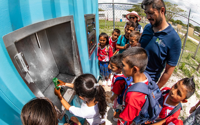 Daniel Ascencio, gerente de IHS para México, con niños de Calakmul, que ahora disfrutan del agua potable purificada de un nuevo sistema WARP